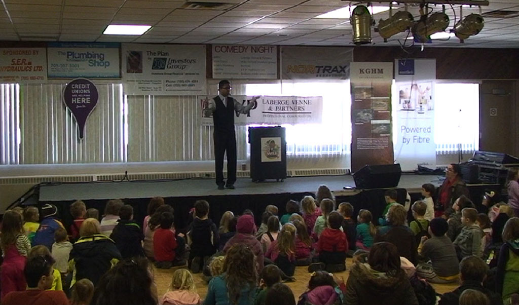 School auditorium magic show with seated audience